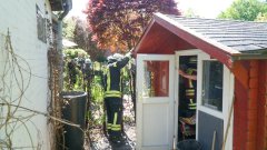 Brennende Hecke an Gartenhaus